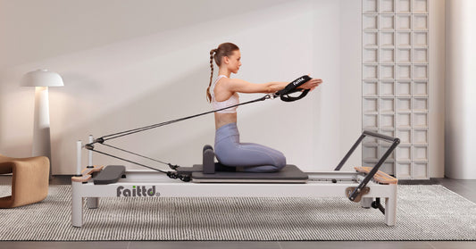 A person performing an arm extension exercise on a Pilates reformer in a minimalist studio setting.